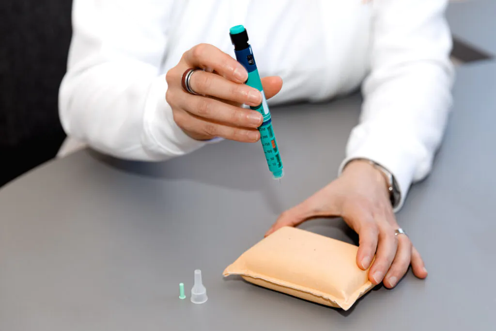 Person performing a diabetes test on practice pad.