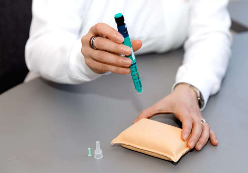 Person performing a diabetes test on practice pad.
